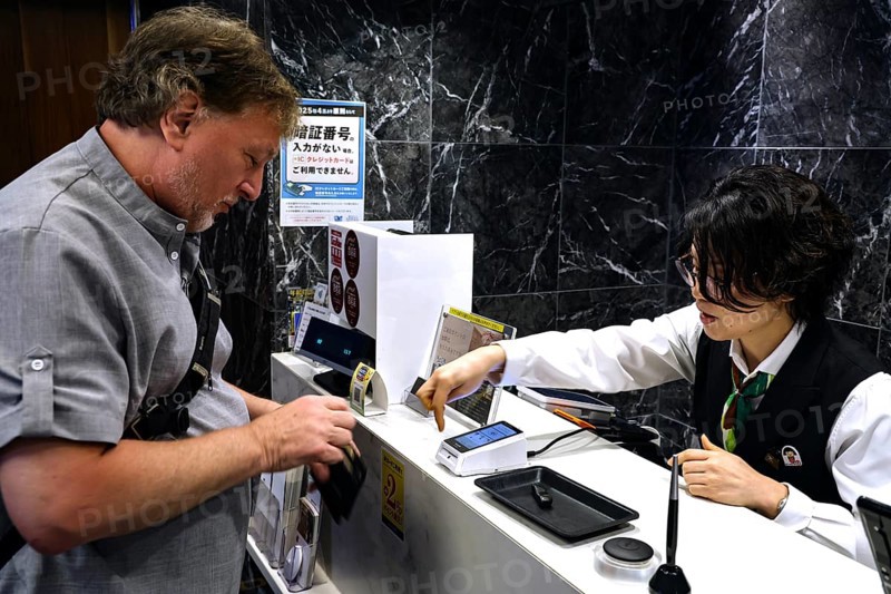 Man pays at the cash register in a restaurant, Kobe, Japan