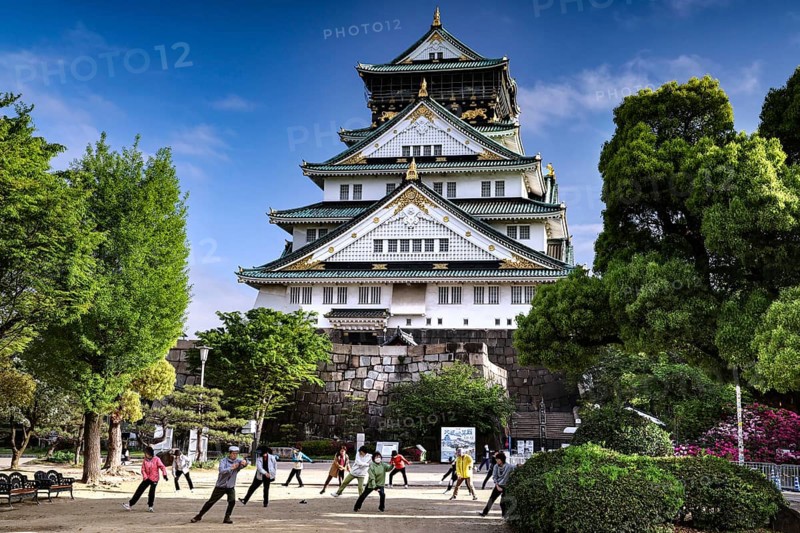 People practice tai chi in front of Osaka Castle, Osaka, Japan