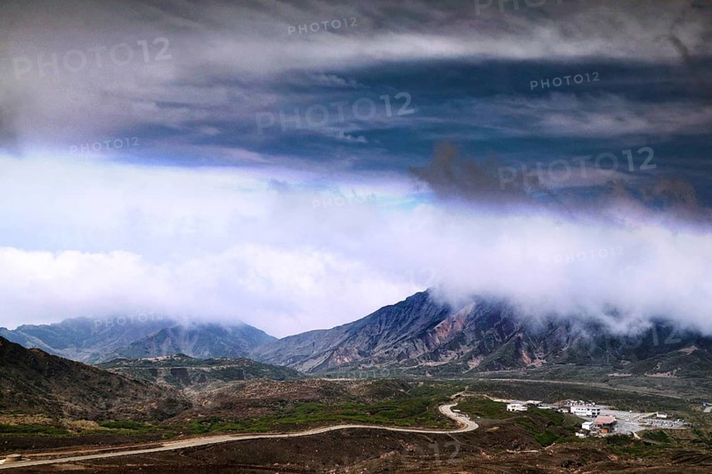 Far-reaching view of mountains and volcanic craters under dramatic cloud formation, Aso, Kumamoto, Japan