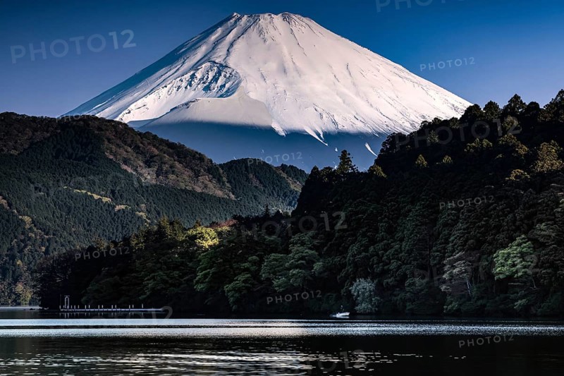 Fujiyama rises majestically over tranquil Lake Ashinoko in bright skies, Hakone, Japan