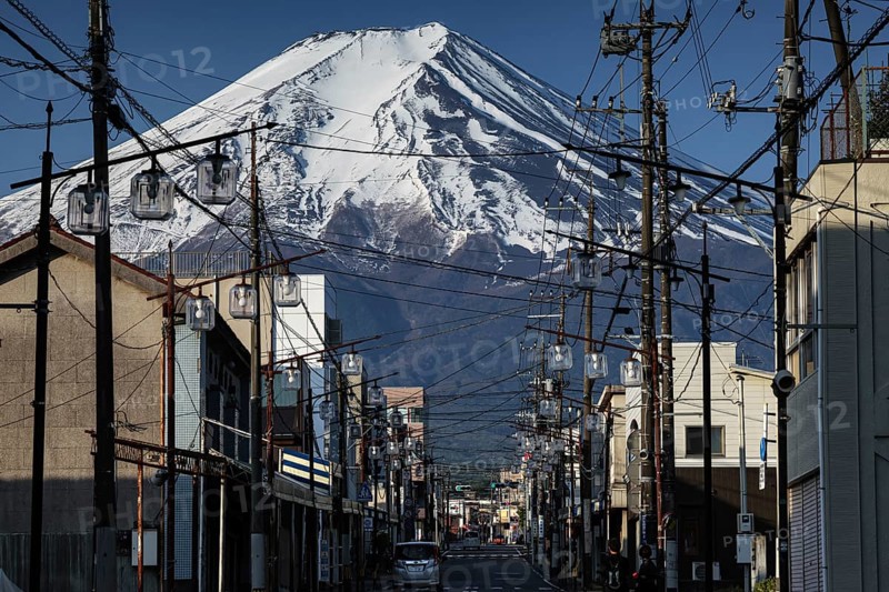 Majestic Fujiyama over a busy street in Fujioshida in golden morning light, Fujioshida, Japan