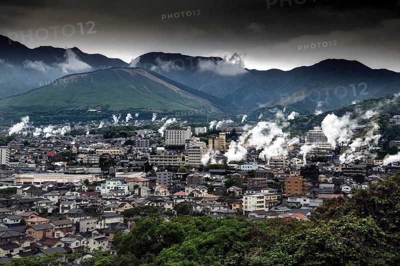 Panorama of a city in mountainous surroundings crossed by rising steam columns, Beppu, Oita, Japan