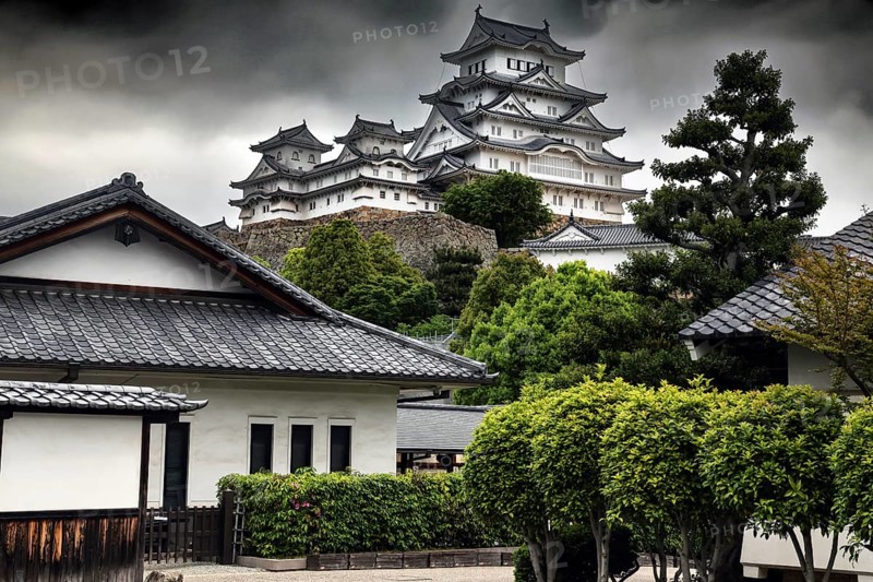 View of the iconic Himeji Castle and surrounding buildings dramatically reinforced by clouds, Himeji, Japan