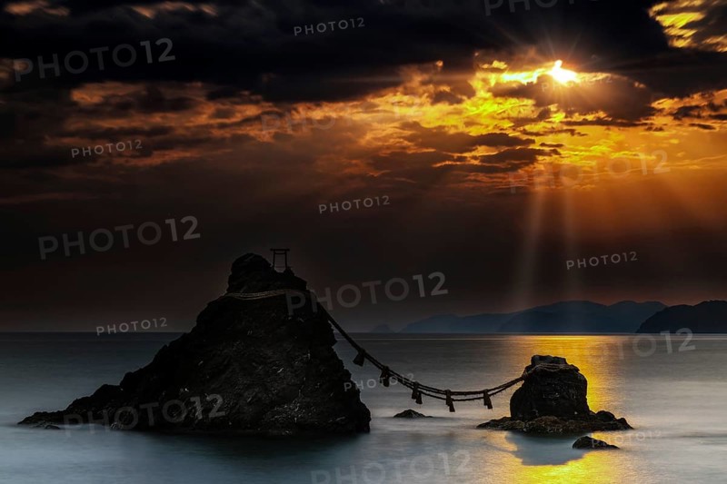 Married rocks at sunrise symbolized by a rope that connects them, Ise, Japan