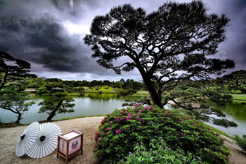 Jardin in Korakuen with a view of the lake and dramatic sunbeams through the clouds, Okayama, Okayama, Japan
