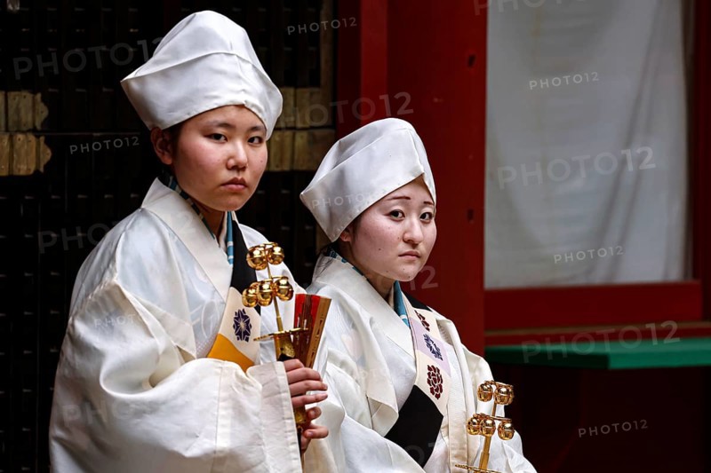 Two female carpenters in traditional dress in the courtyard of Toshogu Shrine, Nikko, Tochigi, Japan