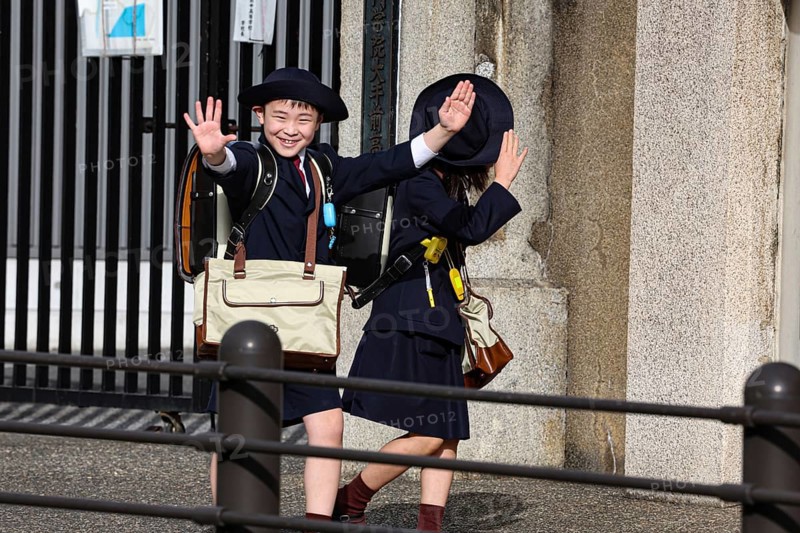 Two laughing schoolchildren in uniforms on their way to school in Osaka, Osaka, Japan