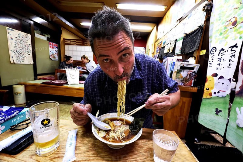 Man enjoying ramen in a cozy Japanese restaurant, Yamanouchi, Japan