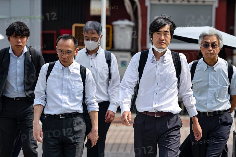 Group of business people in suits walking down the street together, Tokyo, Minato, Japan