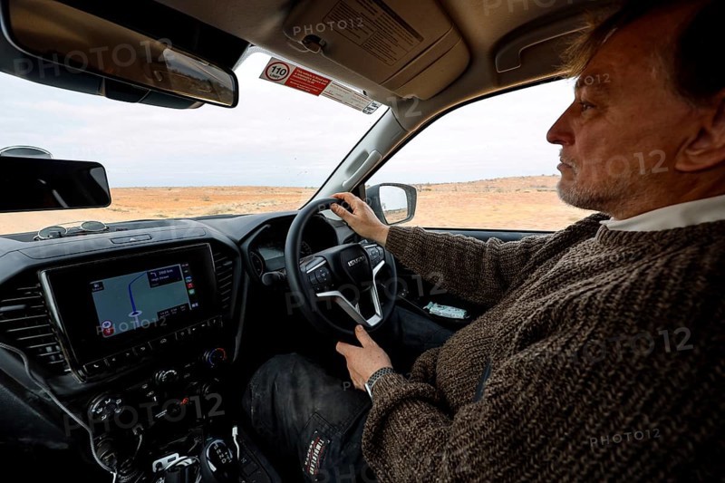 Man in a car on an off-road track in the outback with navigation system, Oodnadatta Track, null, Australia