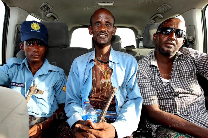 Three people sit in a Landcruiser in Ahmedela while talking, Ahmedela, Ethiopia