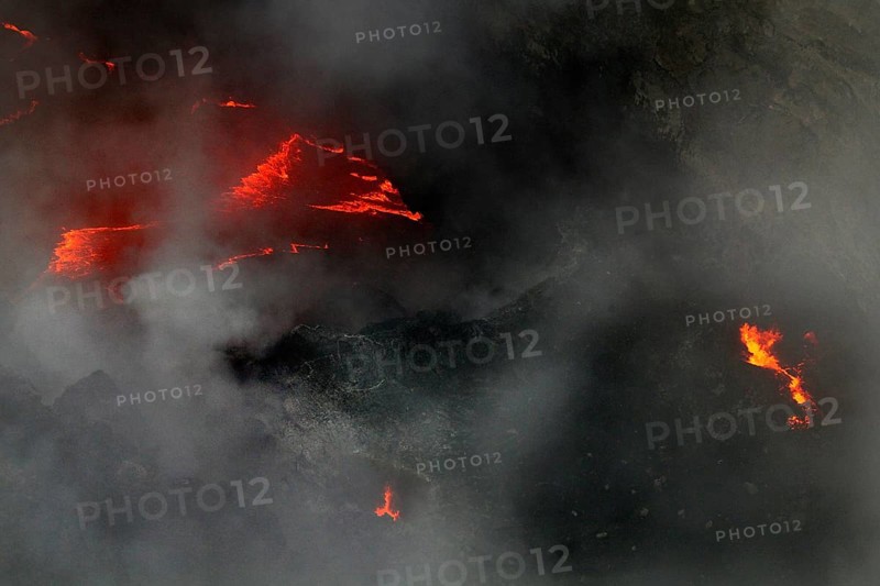 Glowing lava breaks through thick steam in the volcano, Erta Ale, Ethiopia