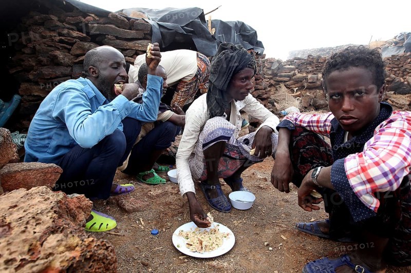 People sitting around the campfire and sharing a meal at Erta Ale camp, Erta Ale, Ethiopia