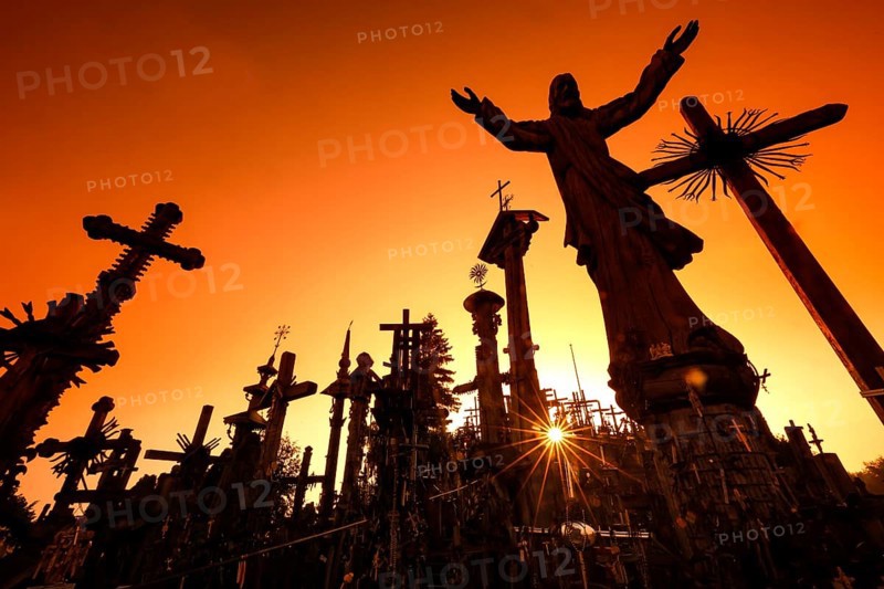 Crosses against light at sunrise on the Hill of Crosses in Siauliai, Siauliai, Lithuania
