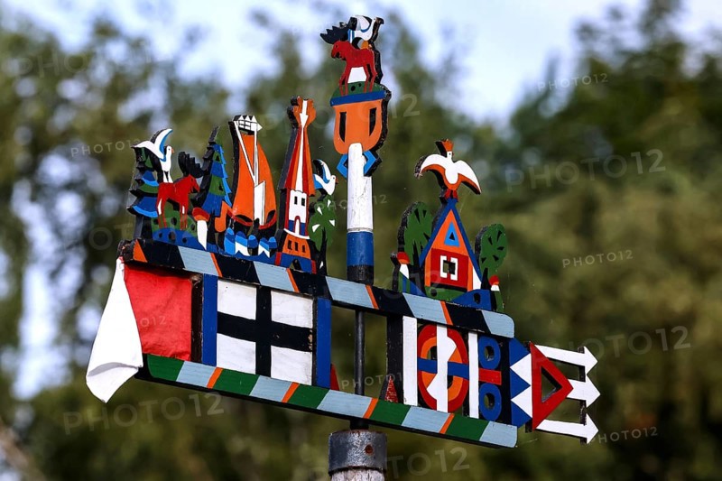 Colourful Kuren pennant with folk symbols in front of blurred trees, Juodkrante, Klaipeda, Lithuania