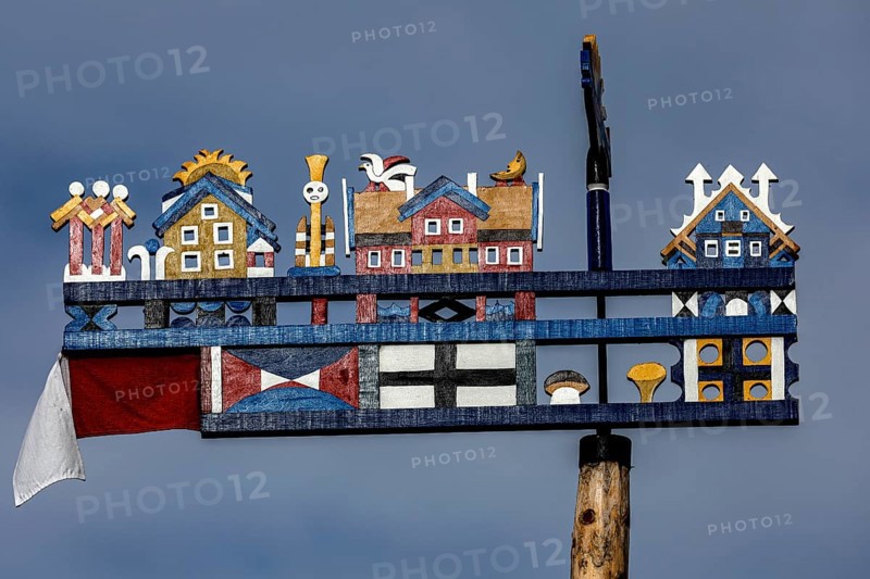 Colourful, traditional Kurenpennant with various symbols against a blue sky, Juodkrante, Klaipeda, Lithuania