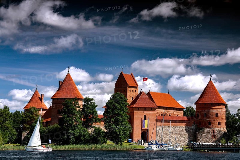 Trakai Castle with sailboats against the cloudy sky over the lake, Trakai, Lithuania