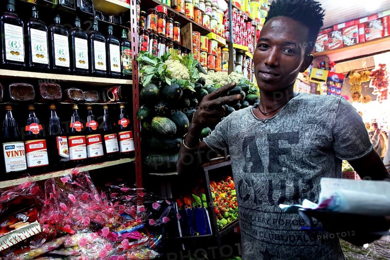 Man in colorful grocery store in Mekele, Ethiopia, between shelves of goods, Mekele, Ethiopia