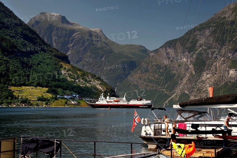 Hurtigruten ship in the fjord with surrounding mountains and water, Geirangerfjord, Norway