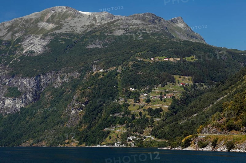 Green mountain slopes with road and fjord views, Geirangerfjord, Norway