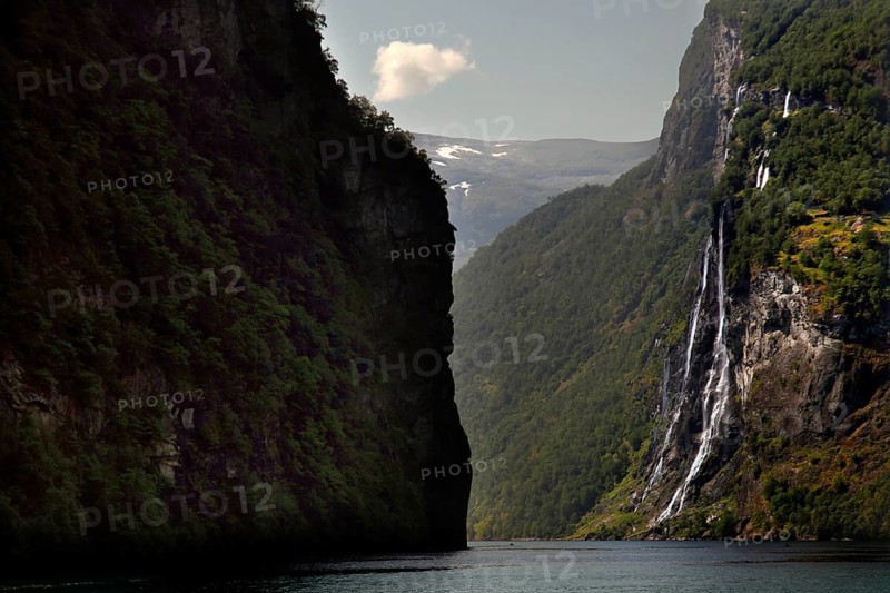 Dramatic waterfall falling in Geirangerfjord surrounded by steep cliffs, Geirangerfjord, Møre og Romsdal, Norway