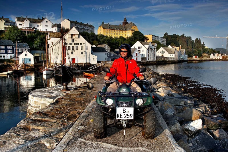 ATV rider on the dock in front of the fishing museum in Ålesund in sunny weather, Ålesund, Møre og Romsdal, Norway