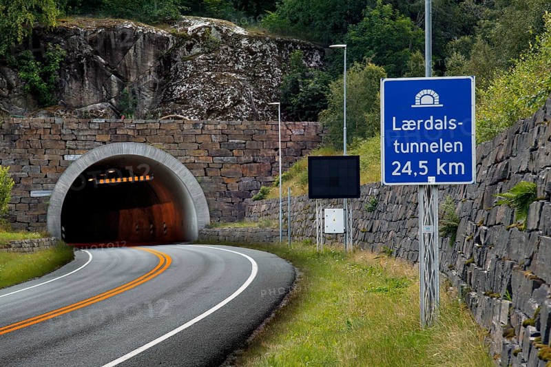 Entrance to the Lærdal Tunnel with road sign in mountainous surroundings, zero