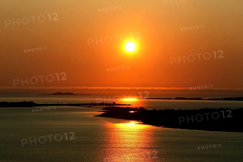 Peaceful sunset scene at Kniven viewpoint in Ålesund with orange sky, Ålesund, Norway