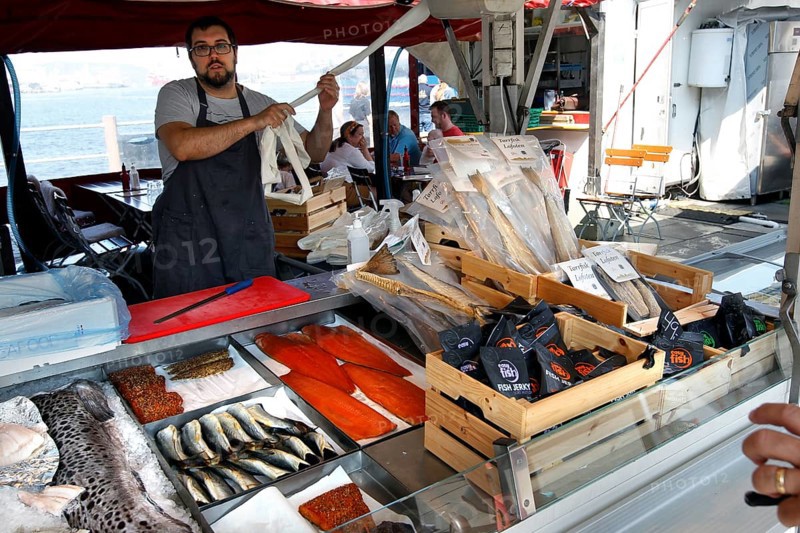 Vendor at fish market selling fresh fish, Bergen, Norway