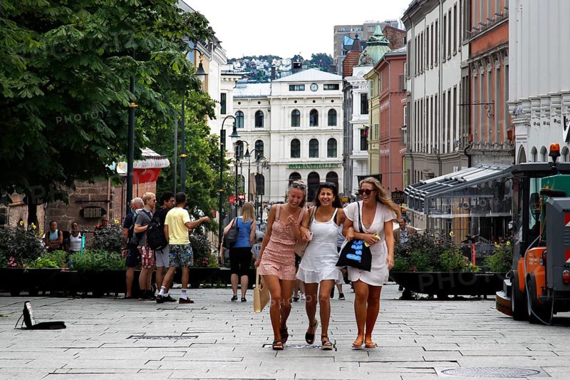 Three woman happily stroll along the busy Karl Johans gate in Oslo, Oslo, Norway