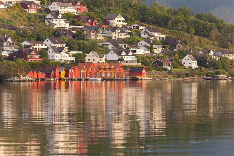 Golden hour light over the harbor and mountains. Summer sunset, Rosendal Port, Vestland, Norway
