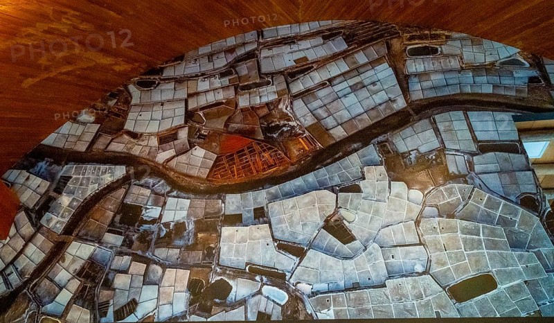 Anana salt pans filling a valley, creating a textured landscape of geometric shapes and water pools, illustrating traditional salt production in the basque country