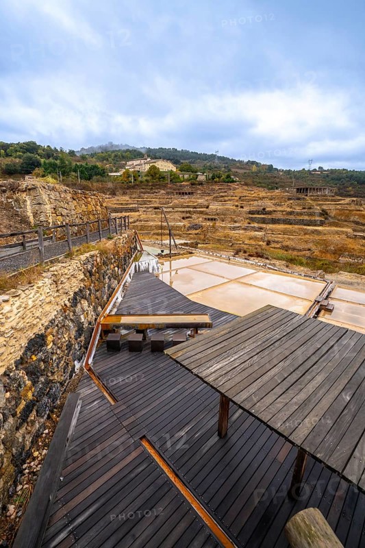 Terraced salt pans of the historic anana salt valley in alava, basque country, reflecting a cloudy sky across ancient evaporation ponds and rural mineral rich landscape