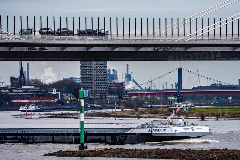 Shipping traffic on the Rhine near Duisburg-Homberg, new A40 motorway, Neuenkamp Rhine bridge, first construction phase, Friedrich-Ebert bridge between Homberg and Ruhrort in the back, industrial setting of the ThyssenKrupp steel plant, North Rhine-Westphalia, Germany