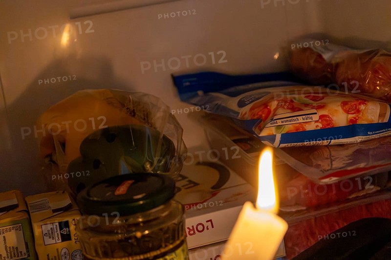 Blackout icon: Illuminating a dark refrigerator with a candle