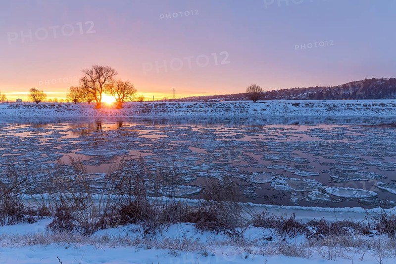 Cold winter morning on the Elbe with floating ice floes, snow and dawn at sunrise, Kötzschenbroda, Radebeul, Saxony, Germany