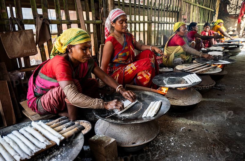 Women prepare 'Pitha', Assamese traditional rice-based sweets or snacks, as part of preparations ahead of the 'Magh Bihu' festival, in Guwahati, Assam, India on January 12, 2026. Magh Bihu, also called Bhogali Bihu, is Assam's harvest festival marking the end of the agricultural season and celebrated with feasts, community bonfires, and traditional food
