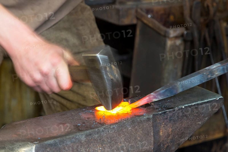 Sparks spray, a blacksmith forging, working at the Ehnert forge in Dresden-Bühlau, Saxony, Germany