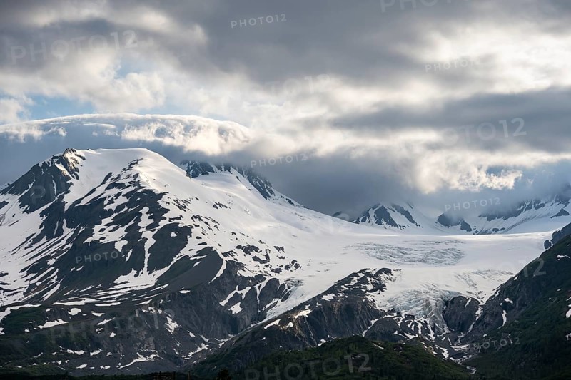 Mountain peak with Worthington Glacier glacier, dramatic cloudy sky, picturesque landscape on Richardson Highway, Chugach Mountains, Alaska, USA