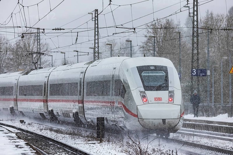ICE traveling through a winter landscape in snowfall. A train on the line in the Deutsche Bahn Amstetten rail network, Baden-Württemberg, Germany
