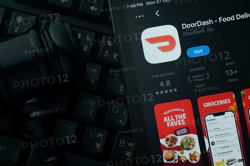 Dhaka, Bangladesh- 28 Oct 2025: An iPad displaying the DoorDash app against a judge's gavel and dark keyboard background