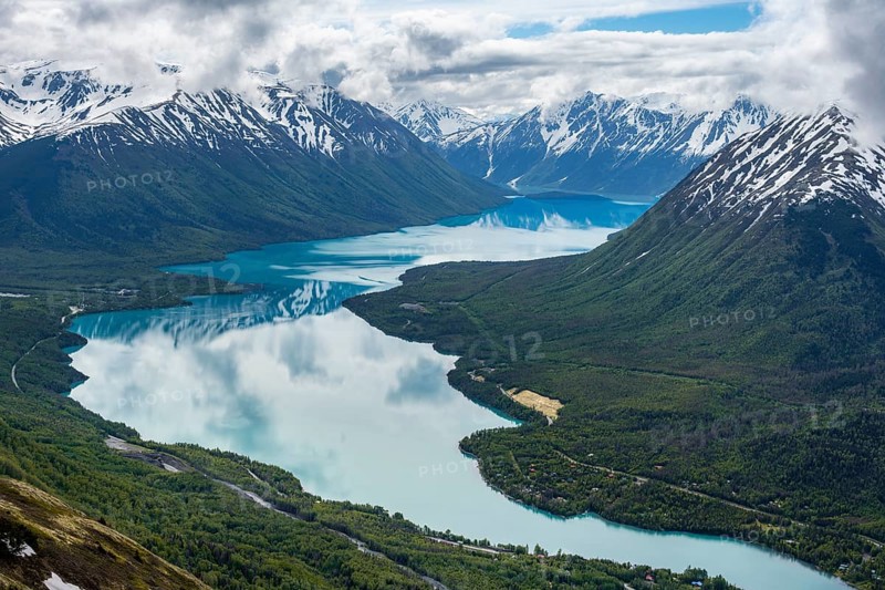 View of snowy mountains in spring and turquoise Kenai Lake with reflection, Slaughter Ridge Trail, Cooper Landing, Kenai Peninsula, Alaska, USA