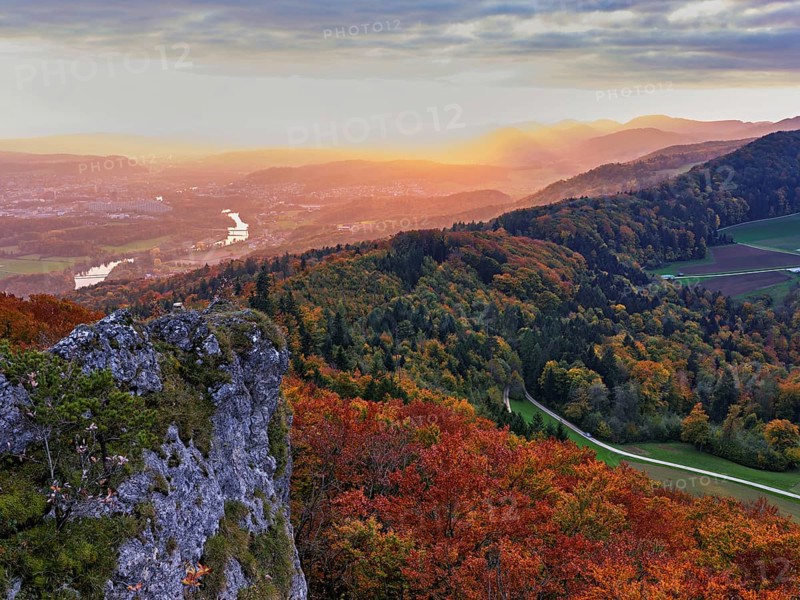 View of an autumnal forest from the Gisliflue, behind the Jurassic foothills in the light of the setting sun, Talheim, Canton, Aargau, Switzerland