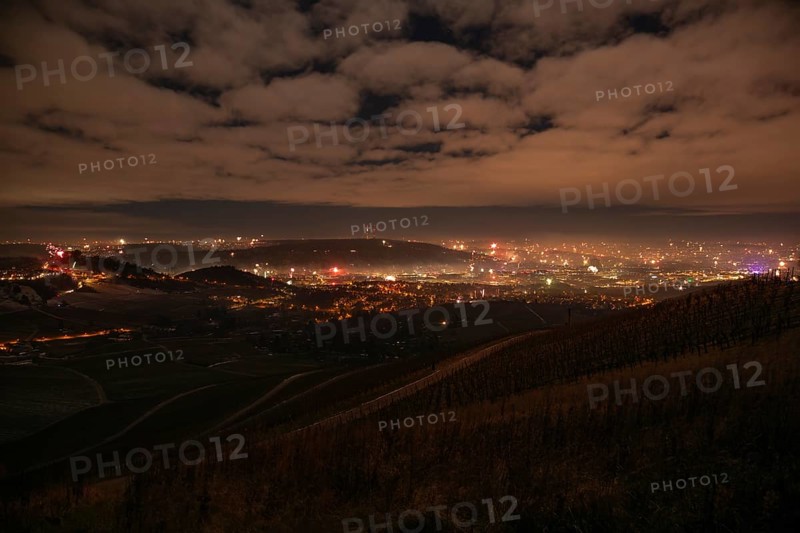 View from Kapellberg near Fellbach across the Neckar Valley to Stuttgart on New Year's Eve from 2025 to 2026. The television tower on the horizon as firecrackers and rockets light up the night sky at the turn of the year and greet the new year