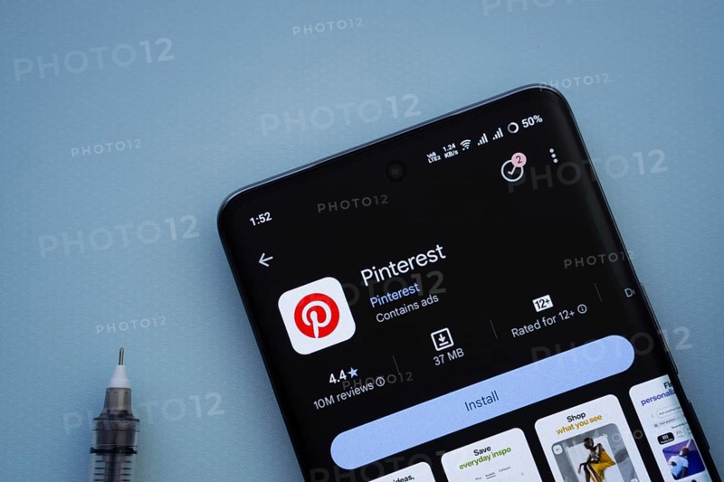 Dhaka, Bangladesh- 29 May 2025: On a blue surface, a smartphone displays the Pinterest app within the Google Play Store
