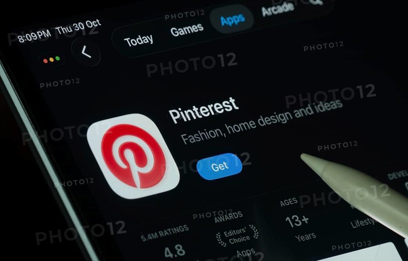 Dhaka, Bangladesh- 30 Oct 2025: Pinterest app displayed on a iPad screen in dark mode with a digital pen pointing at it