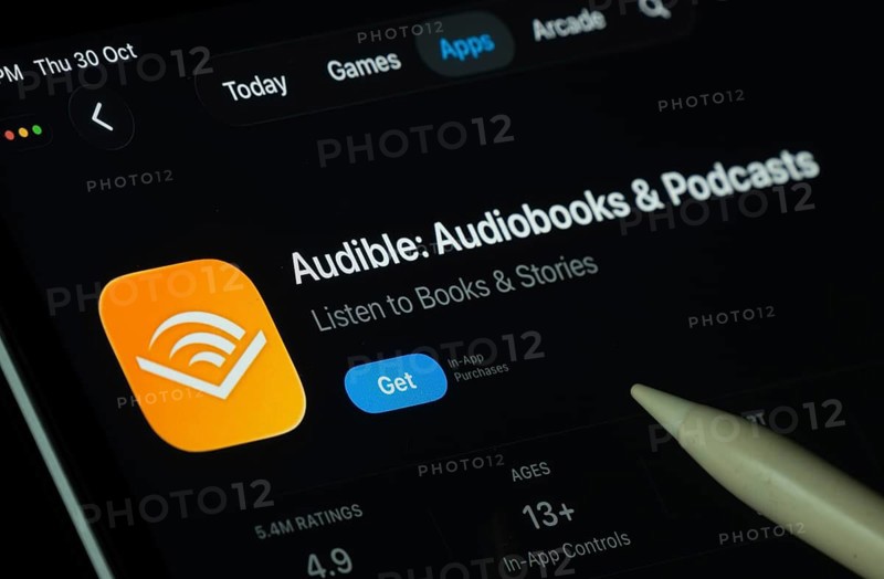 Dhaka, Bangladesh- 30 Oct 2025: Audible app displayed on a iPad screen in dark mode with a digital pen pointing at it