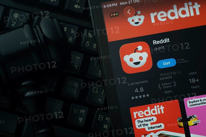 Dhaka, Bangladesh- 28 Oct 2025: An iPad displaying the Reddit app against a judge's gavel and dark keyboard background