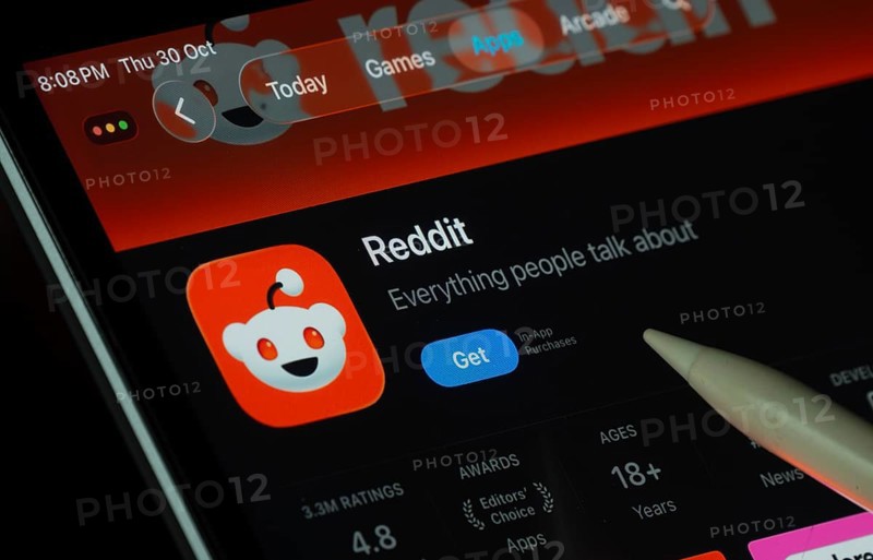 Dhaka, Bangladesh- 30 Oct 2025: Reddit app displayed on a iPad screen in dark mode with a digital pen pointing at it