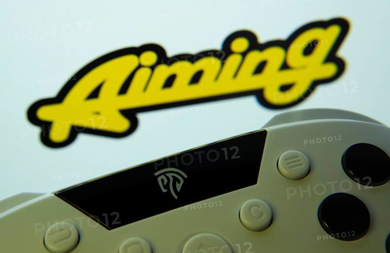 Dhaka, Bangladesh- 24 Mar 2025: A close-up of a gamepad with the Aiming Inc seen on screen in the background